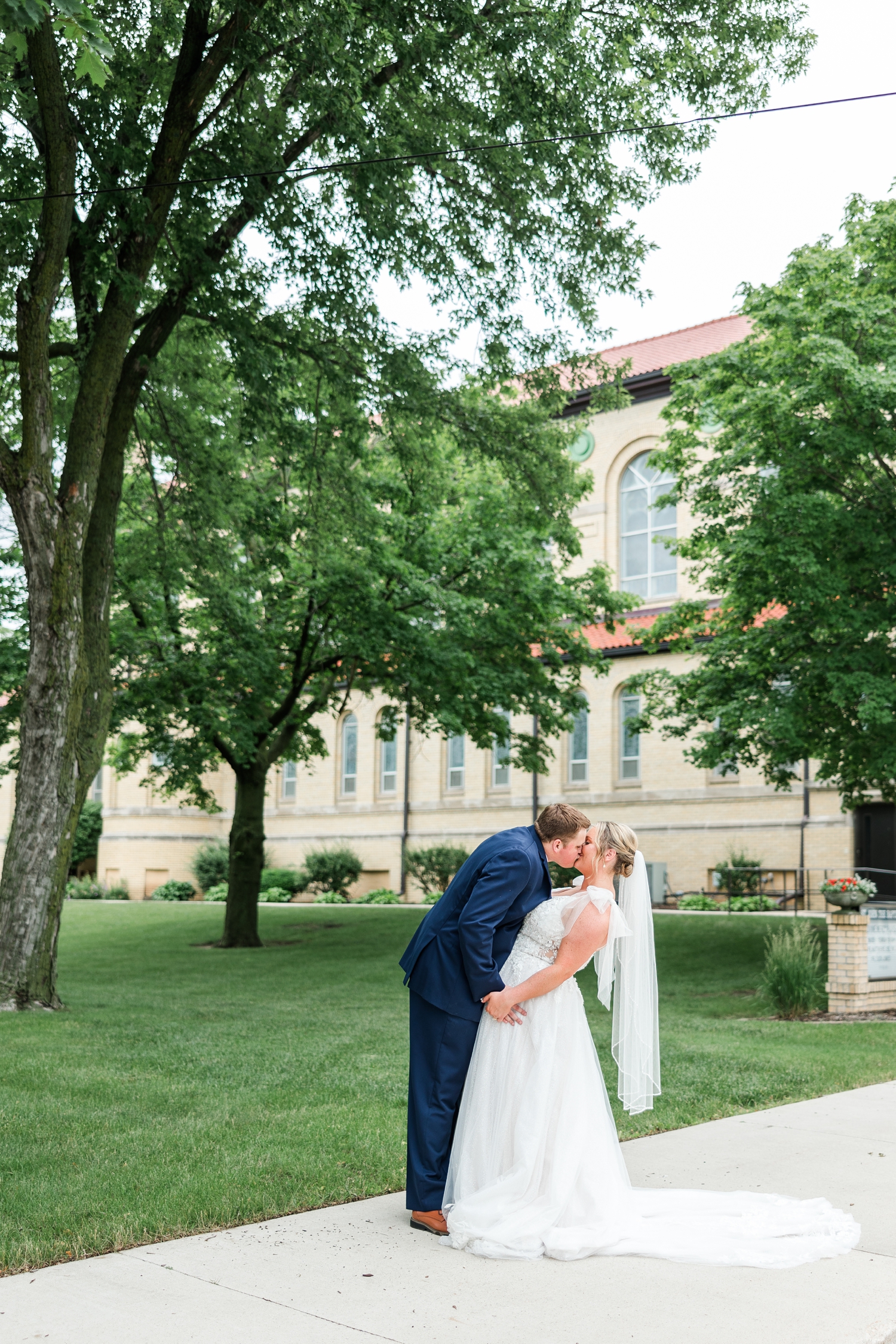 Shelby and Taylor share a kiss in front of St. John the Baptist Catholic Church in Bancroft, IA | CB Studio