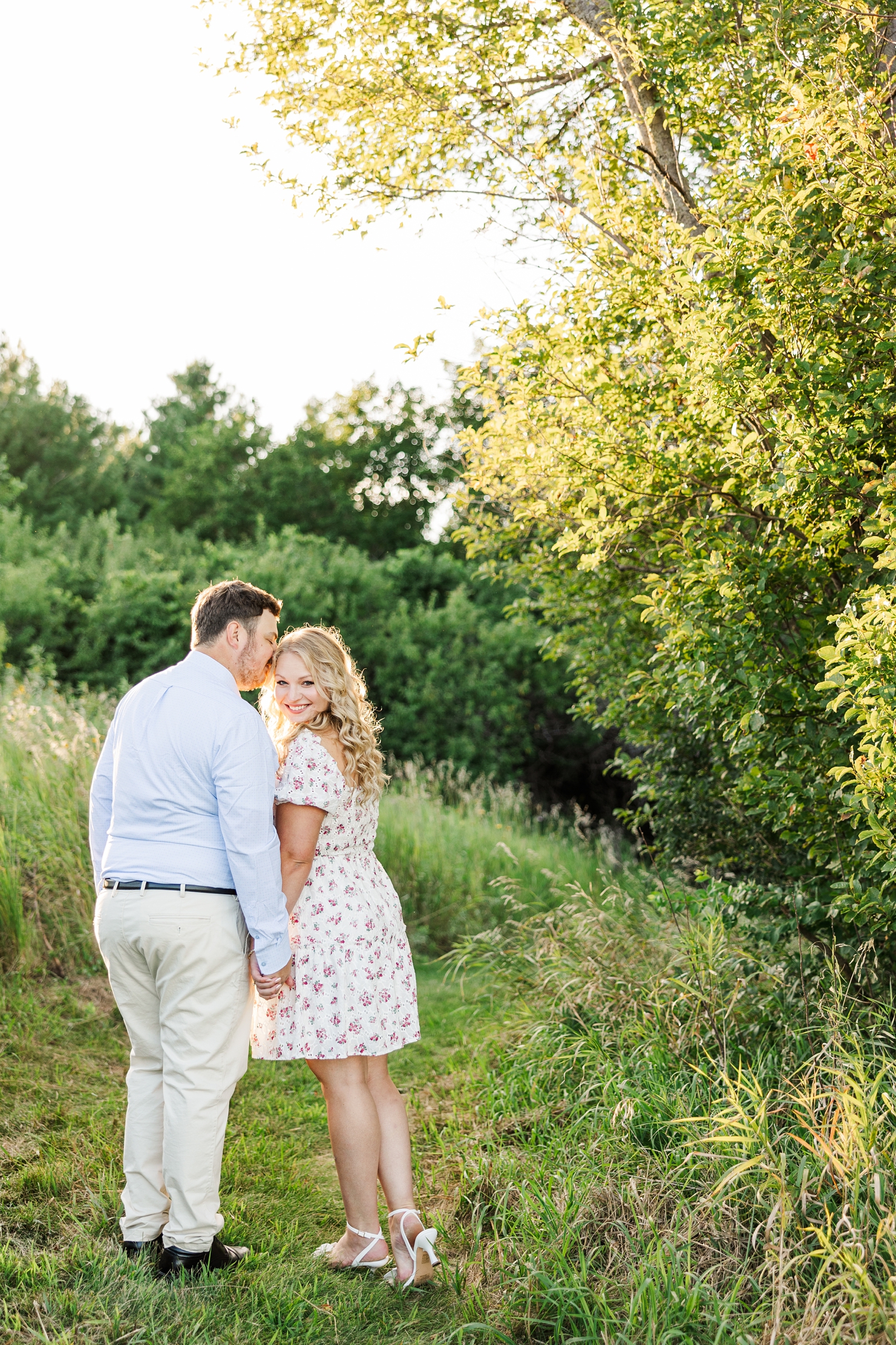 Connor nuzzles the side of Natalie's head while she smiles looking over the back of her shoulder at Water's Edge Nature Center | CB Studio