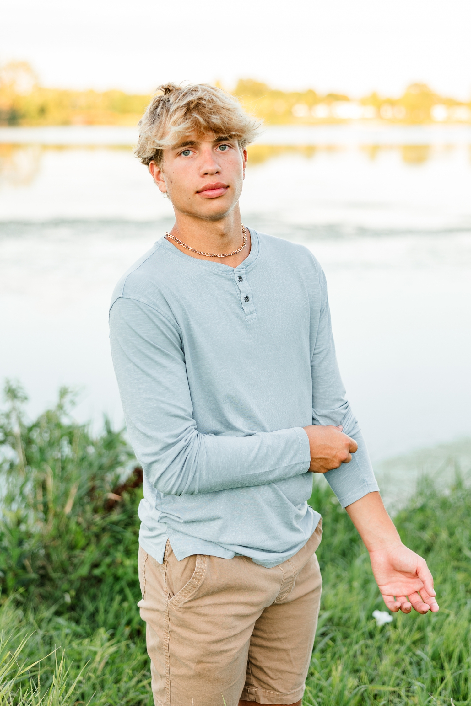 Tyler slowly pulls his sleeve up while standing in front of Smith Lake in Algona, IA | CB Studio