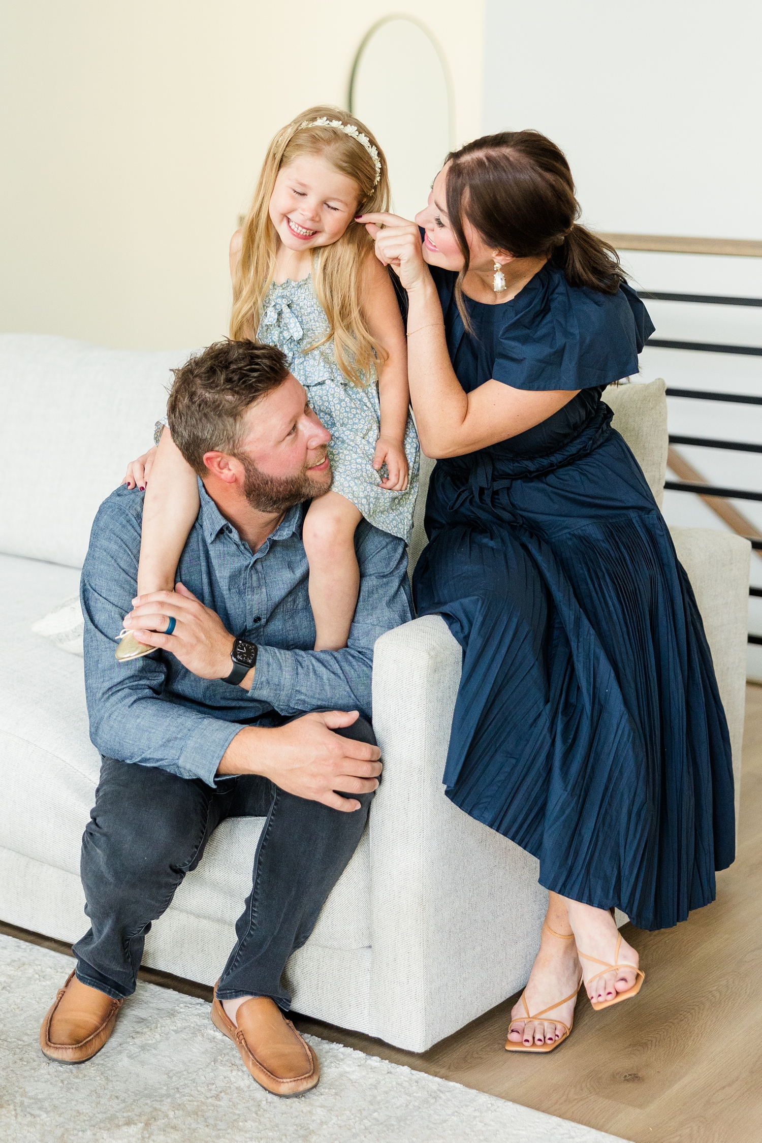 The Arndorfers sit on the edge of their couch in their new, modern home for an in-home lifestyle family photoshoot | CB Studio