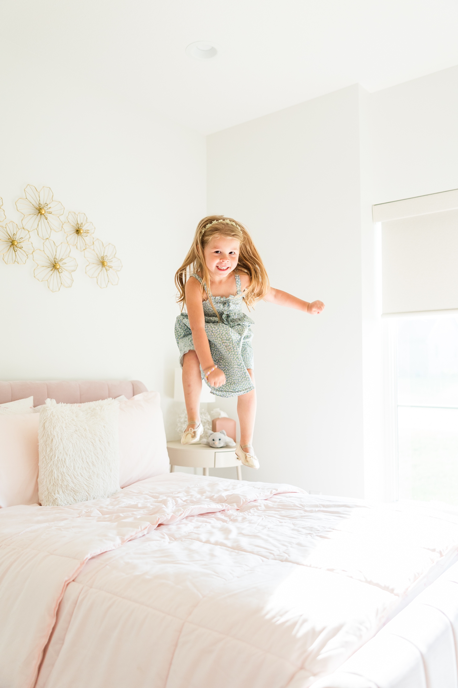 Jade jumps on her new pink bed in her new, modern home for a lifestyle family photoshoot | CB Studio