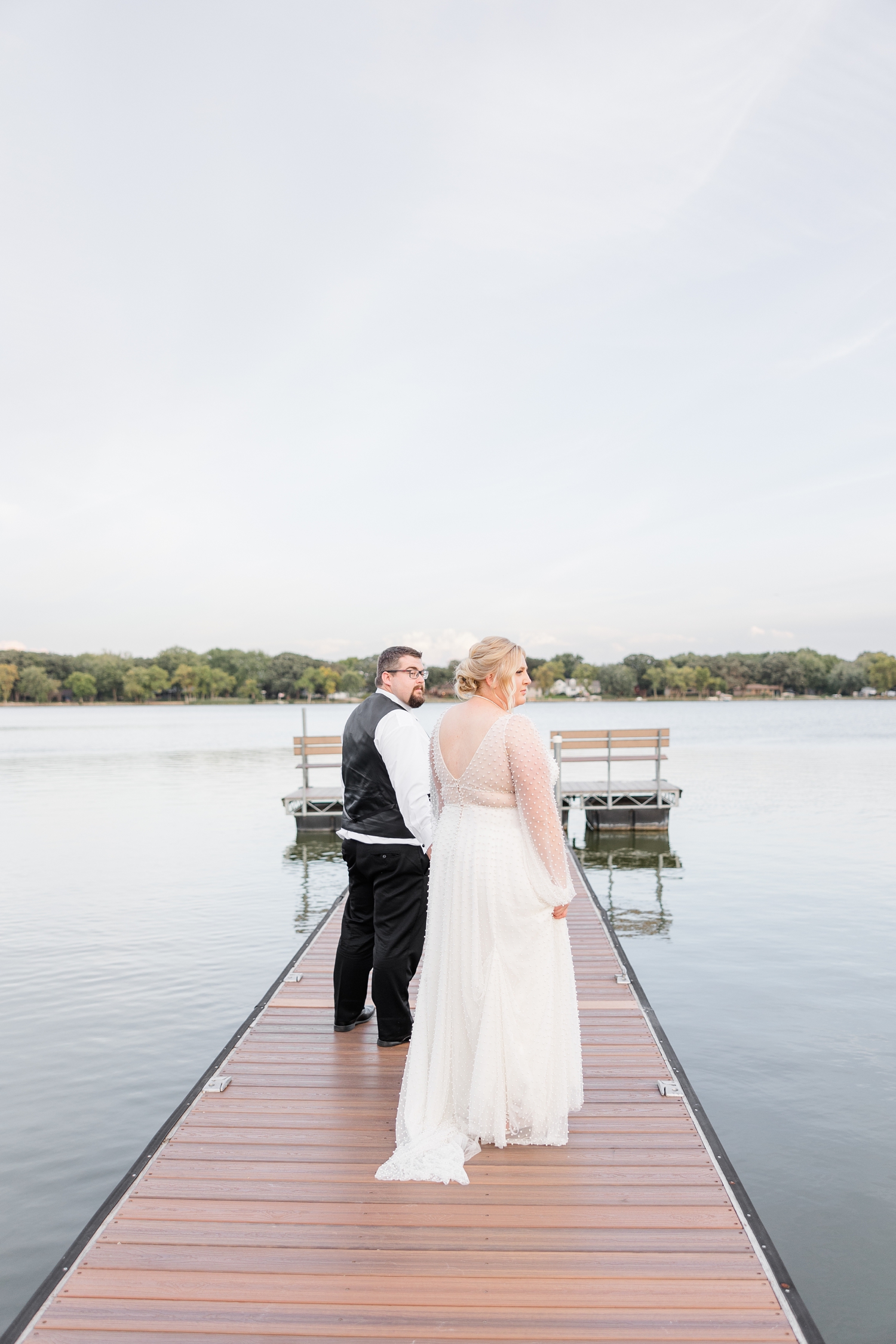 Halie and Nick walk out on the dock towards the lake at The Shores at Five Island | CB Studio