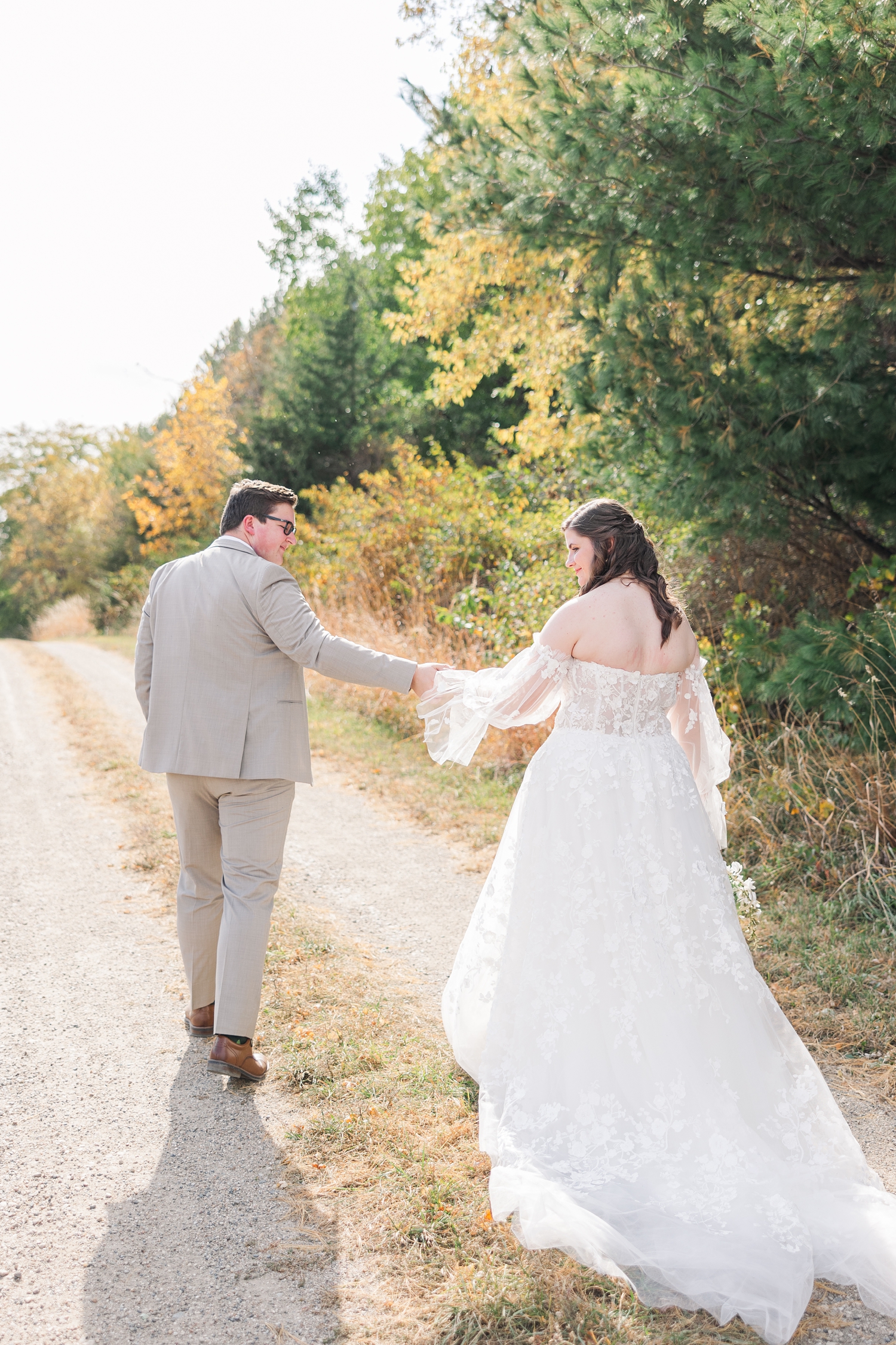 Kevin leads Myra down a dirt path surrounded by fall foliage at Water's Edge Nature Center | CB Studio