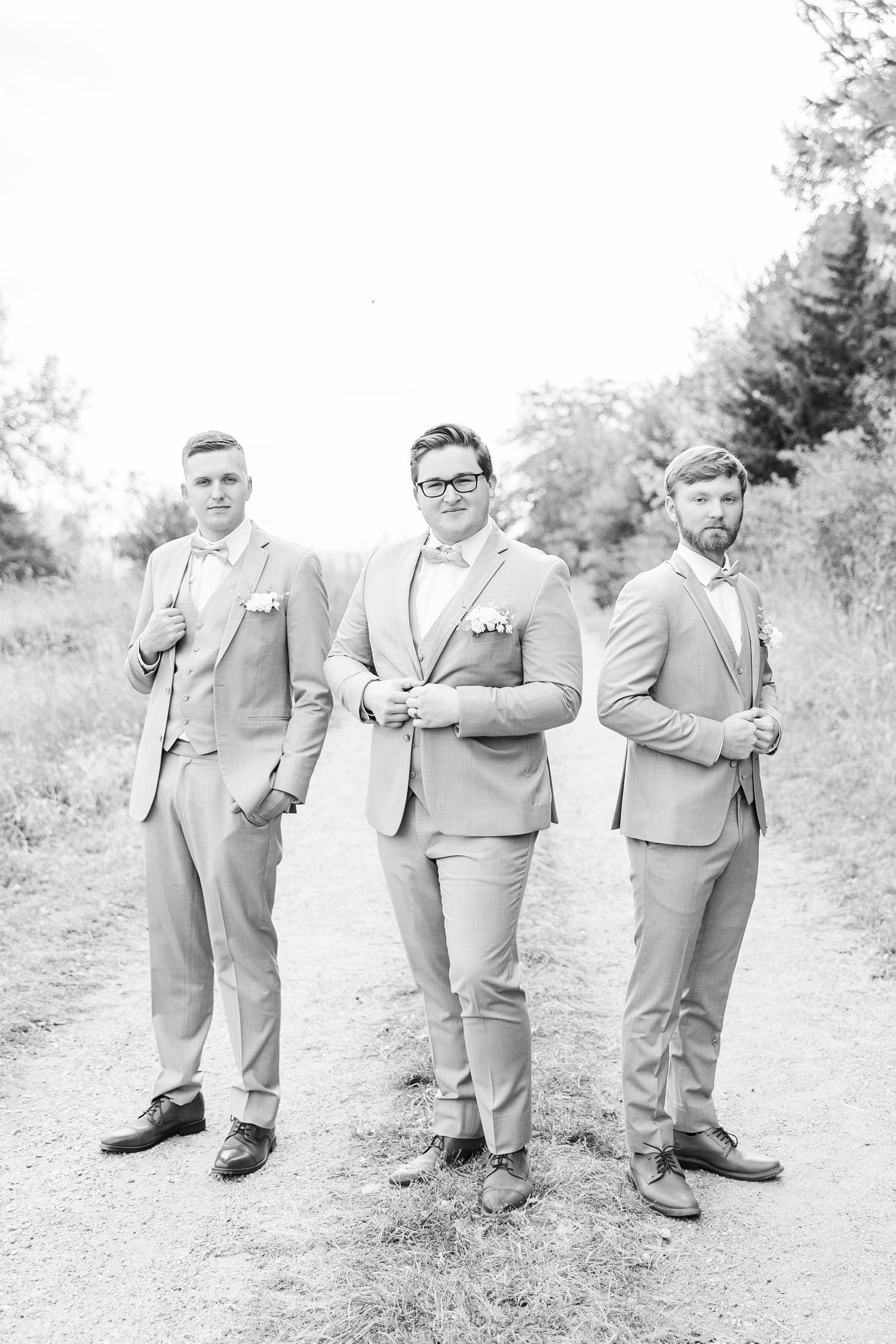 Kevin and his two groomsmen stand stoically on a dirt path at Water's Edge Nature Center | CB Studio