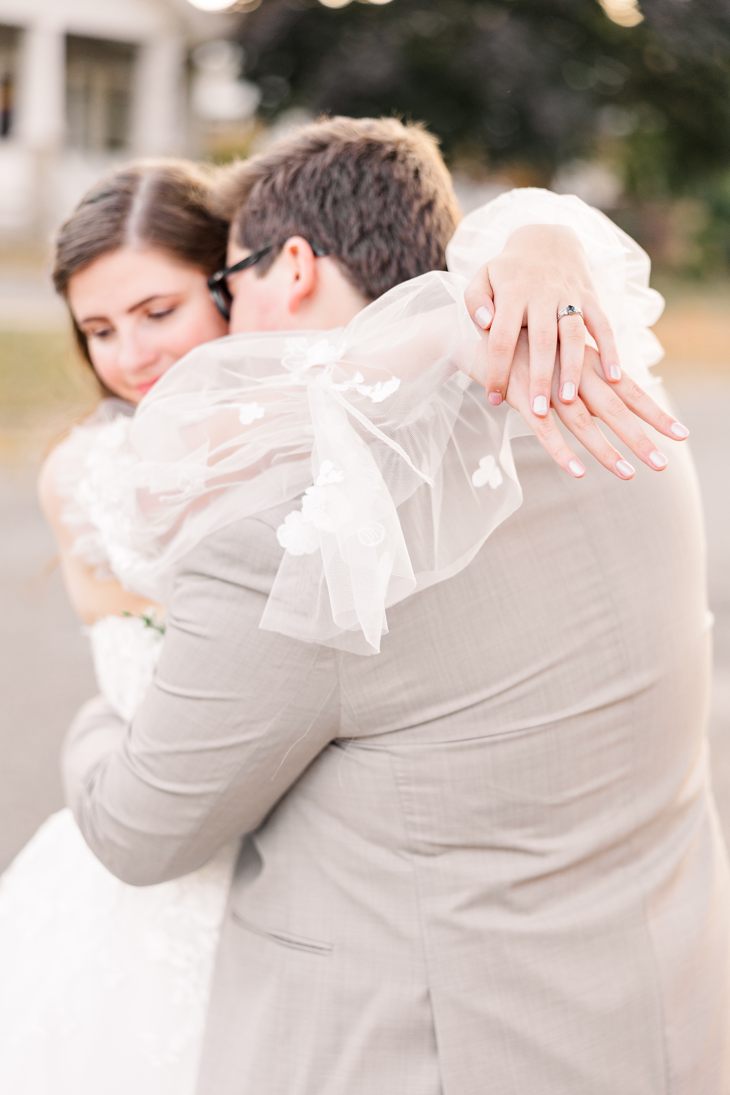 Close up of Myra's hands and wedding rings as she wraps her arms around Kevin's shoulders | CB Studio