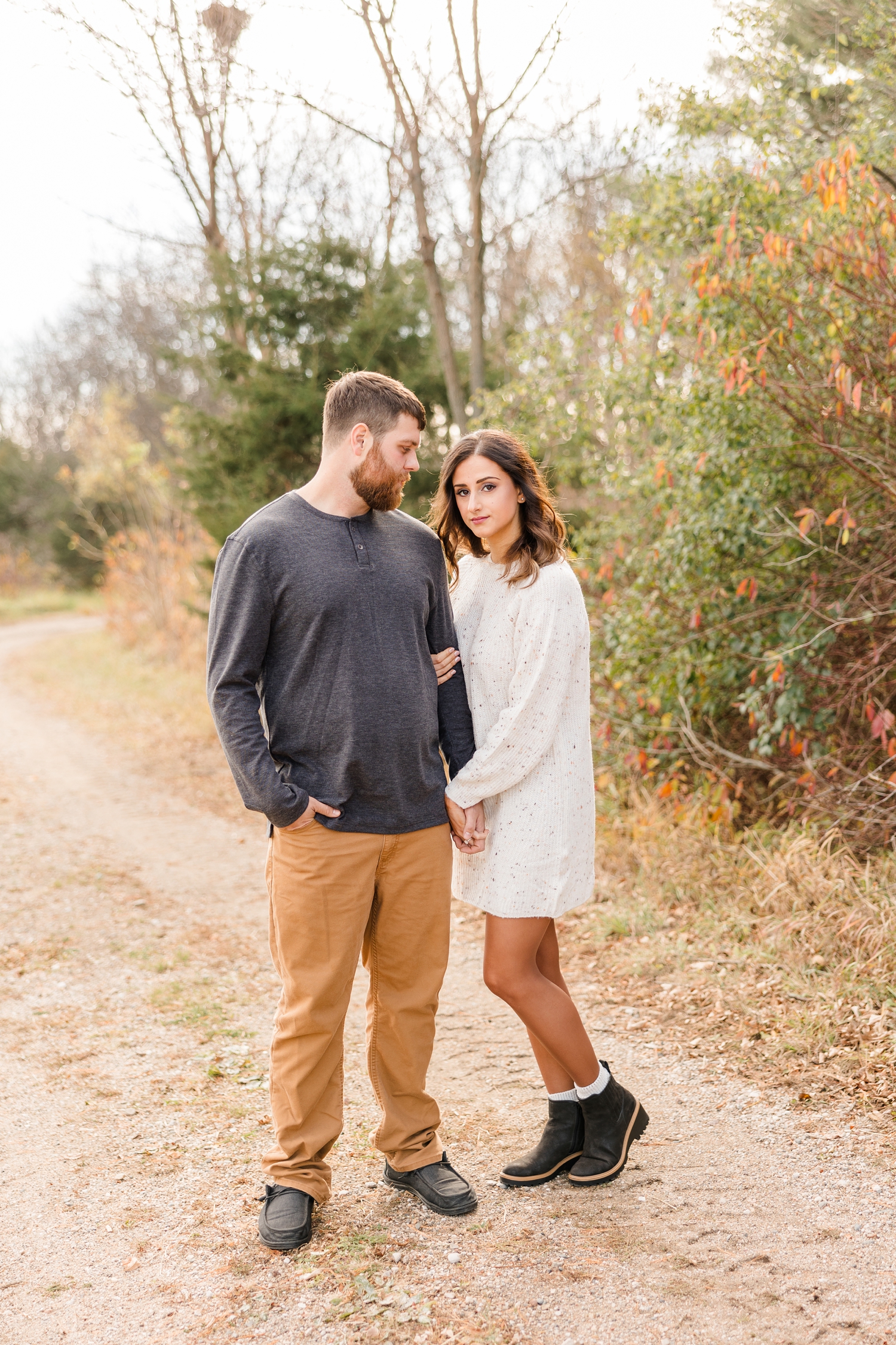 Drake looks at Kylie while they hold hands on a path at Water's Edge Nature Center | CB Studio