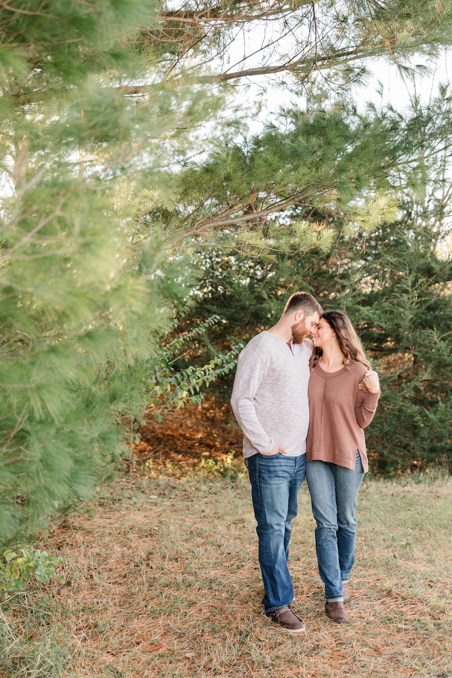 Drake, with his arm around Kylie's shoulder, pauses their walk and they rest their foreheads together while surrounded by evergreen trees | CB Studio