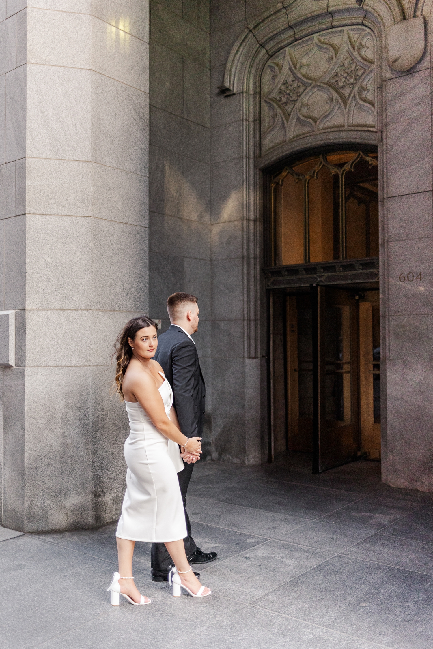 Best of 2024 Engagements | Jenna and Dustin walk hand in hand as they walk into the The Equitable Building in Des Moines, IA | CB Studio