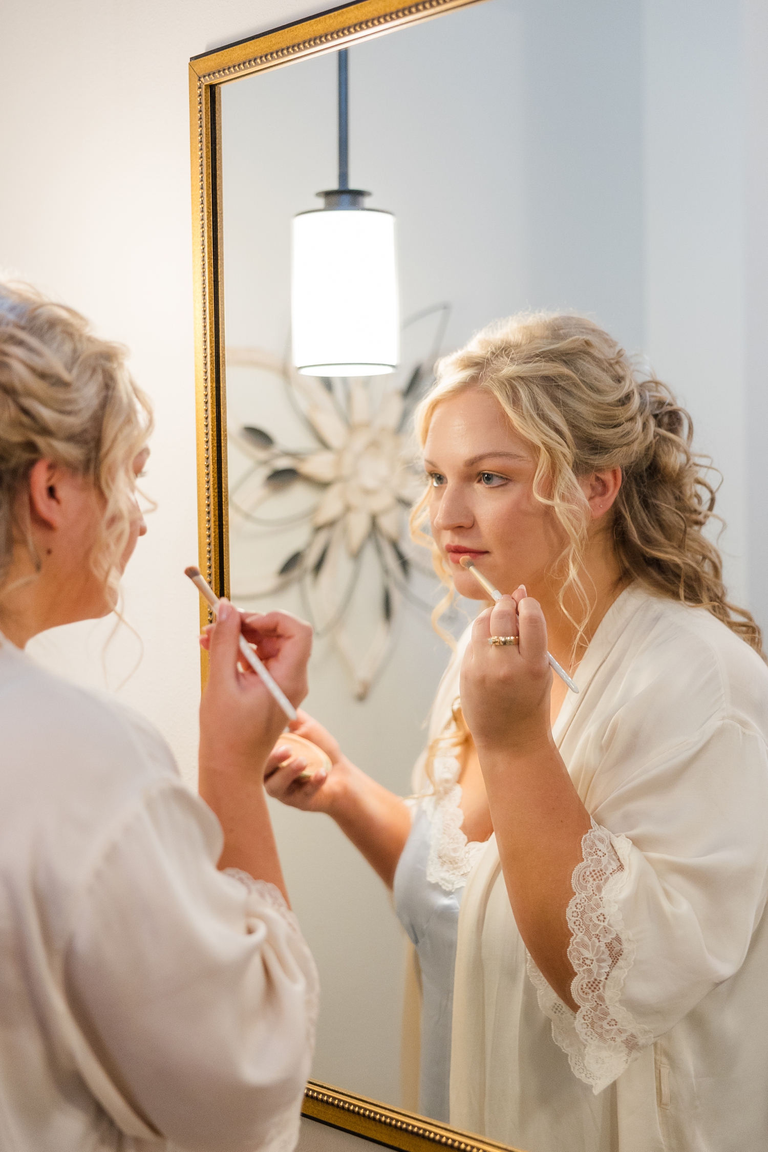 Natalie applies her makeup in the soft lighting of Impulse Salon in Armstrong, IA | CB Studio