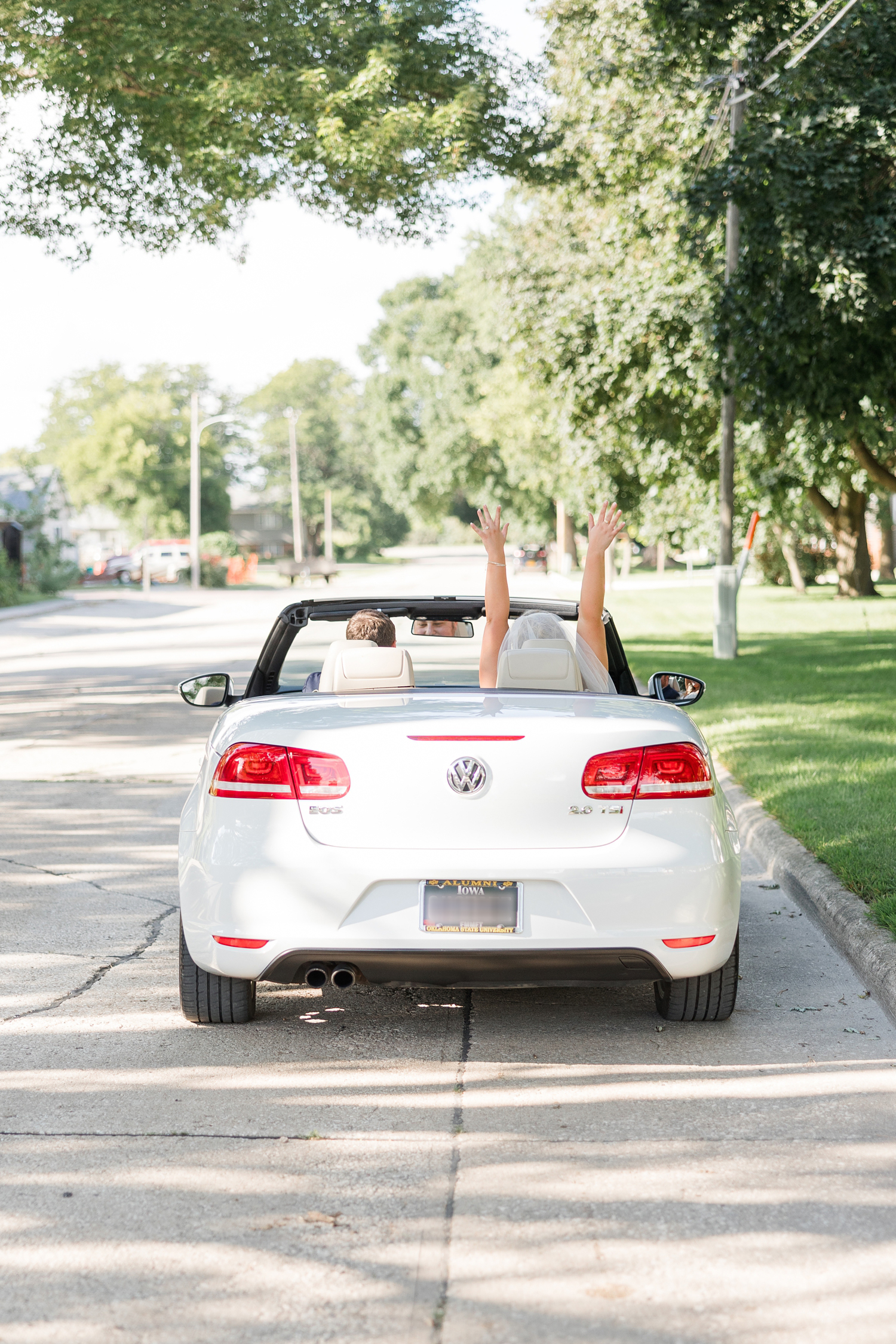 Natalie throws her arms in the air while Conner and her drive away from the church after they were wed | CB Studio