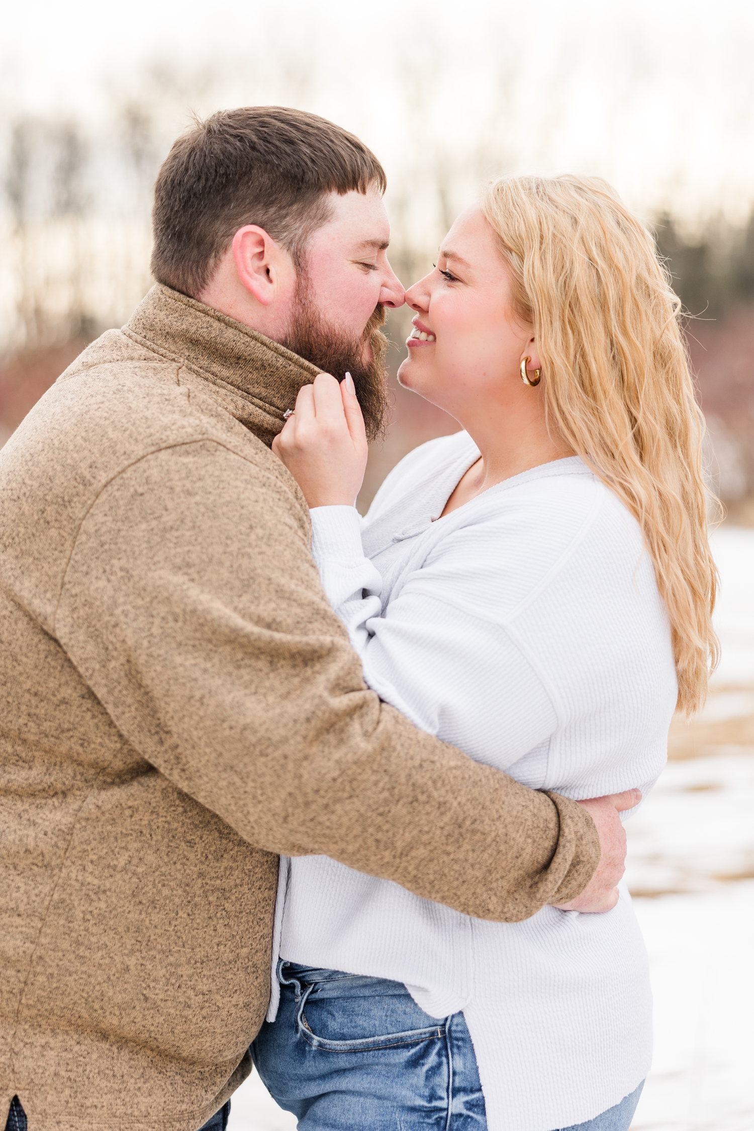 Teri pulls Dalton in close by his collar and they both touch noses at Water's Edge Nature Center during early spring in Iowa | CB Studio