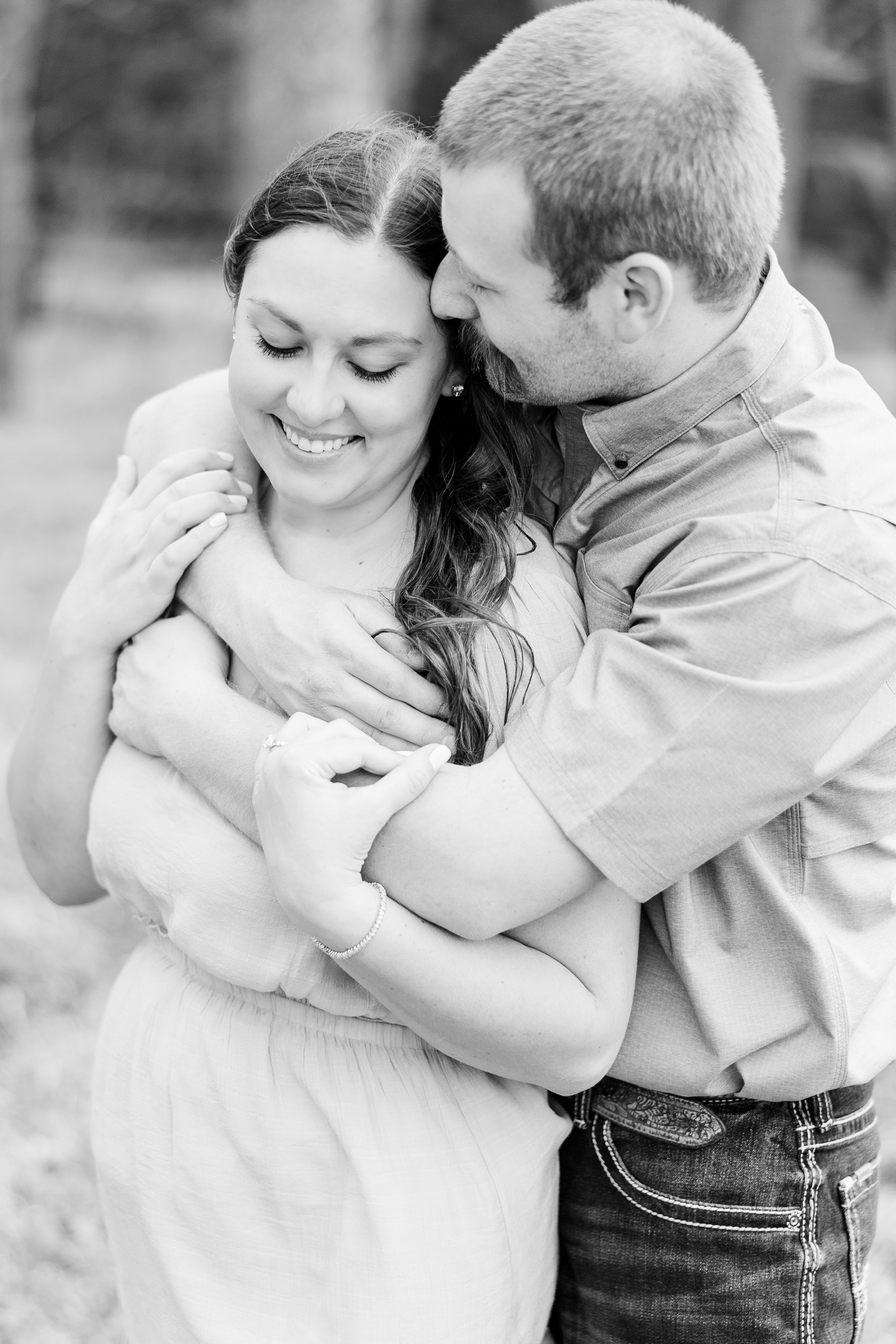 Ryan embraces Cassie's shoulders and nuzzles her temple as she looks down and smiles | CB Studio