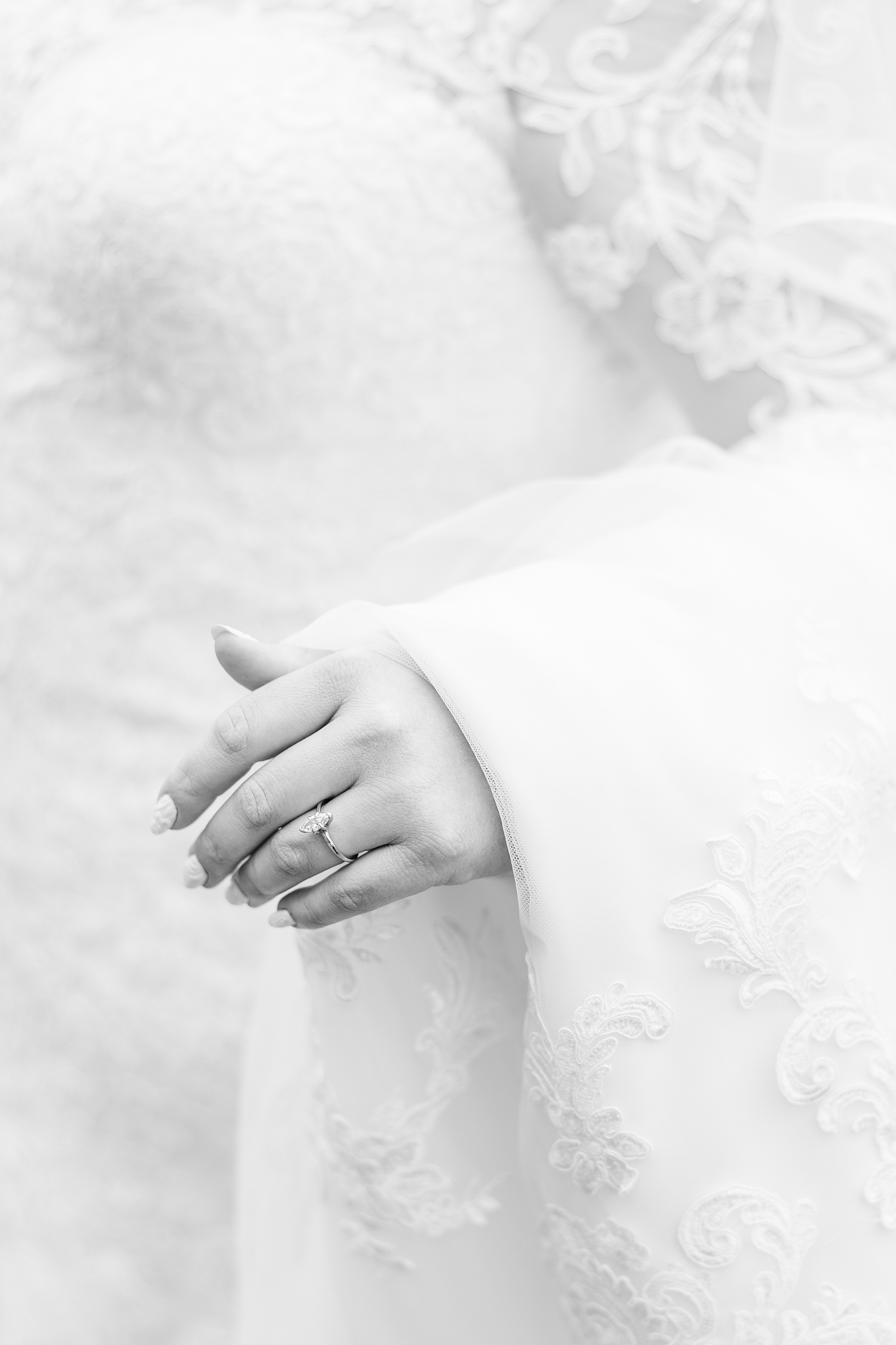 Close up detail of Sydney's hand wearing her marquis engagement ring as her wedding dress train drapes over her arm | CB Studio
