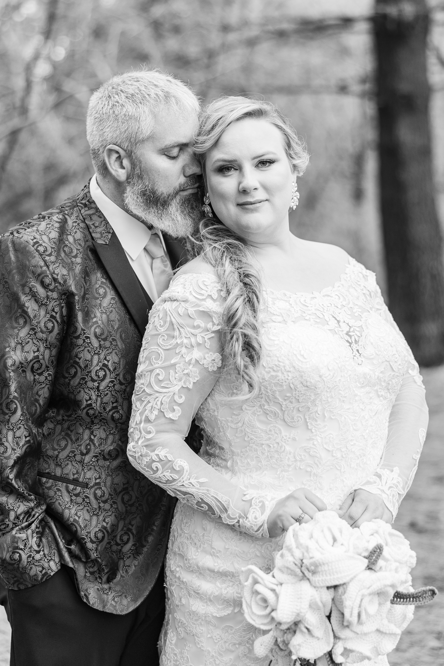 Nick stands behind Sydney and gently sniffs her hair as they stand beneath the pines of the Water's Edge Nature Center | CB Studio