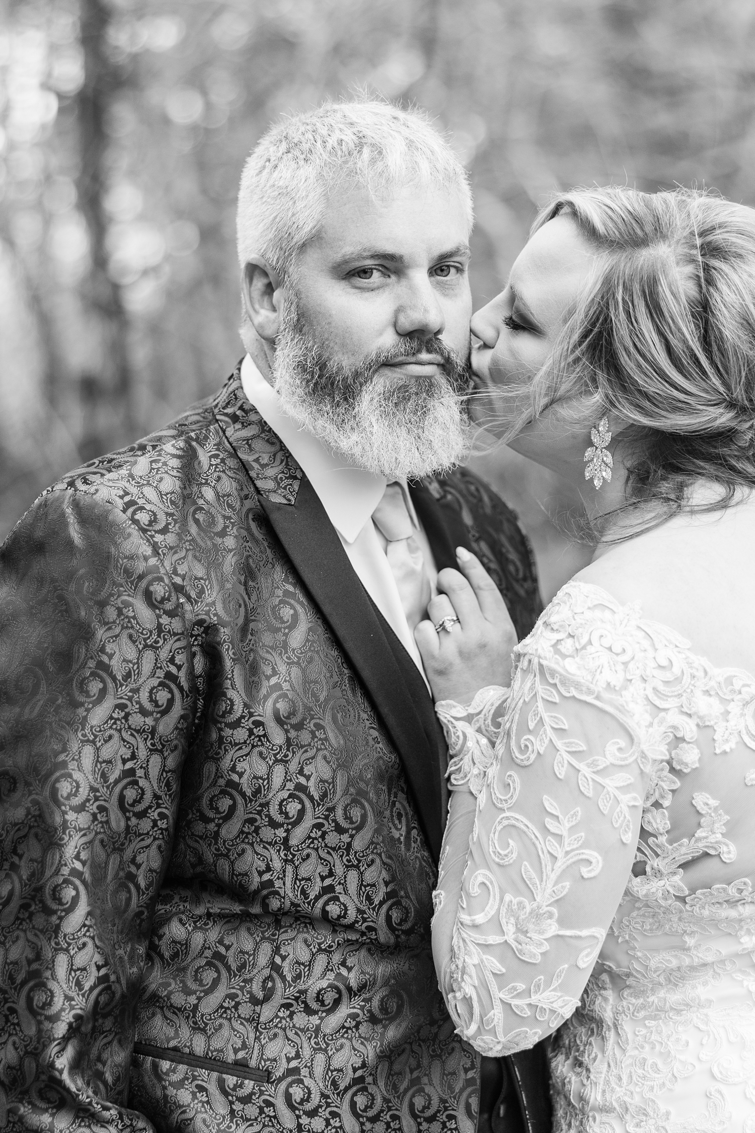 Sydney leans in, grabs Nick's lapel, and kisses his cheek as he stoically looks forward | CB Studio