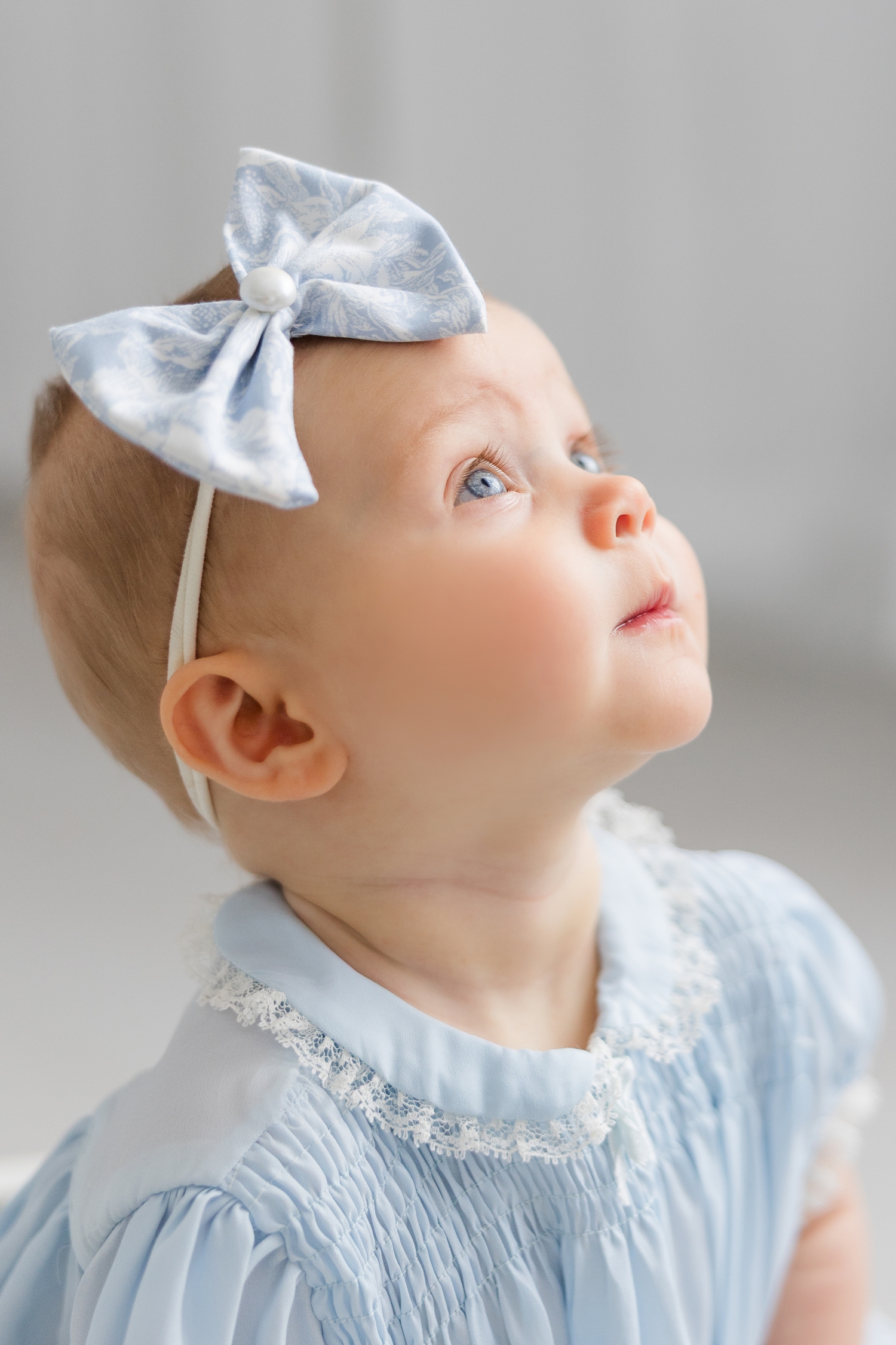 A profile view with a focus on Baby Adalyn's eyes. Adalyn is wearing a light blue vintage dress that was her grandmother's dress when she was a baby | CB Studio
