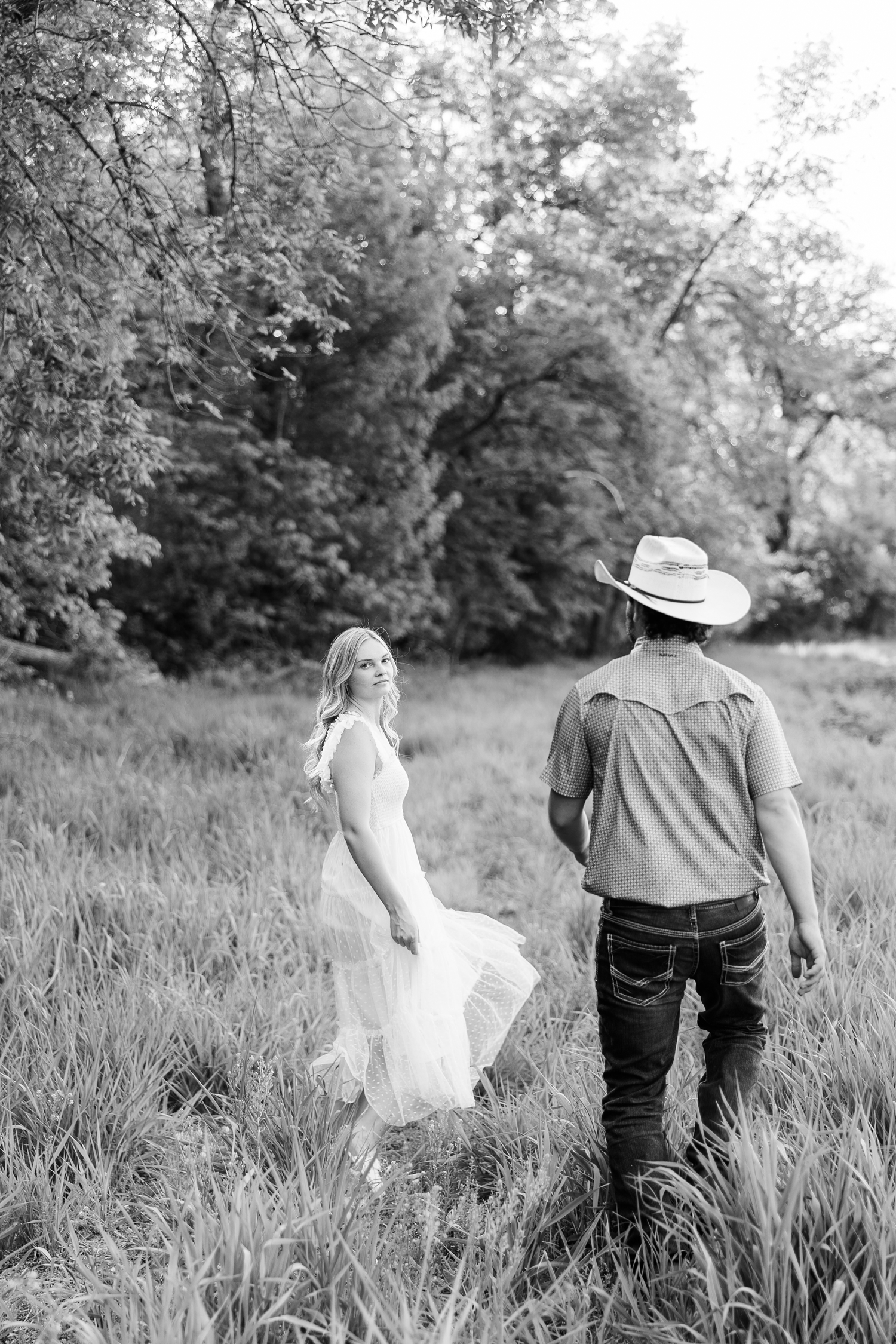 Jade looks back as her and Dawson walk through a grassy pasture | CB Studio