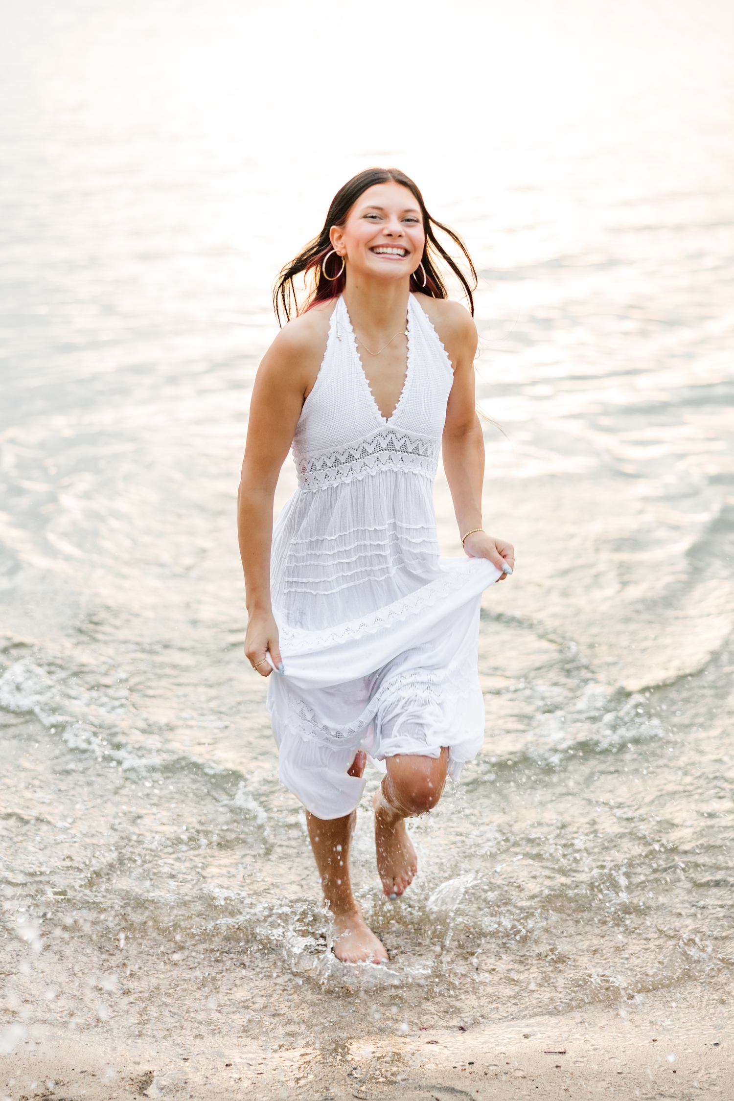 Brooke, wearing a long white linen dress, runs to the shore of West Okoboji Lake at Pikes Point State Park | CB Studio