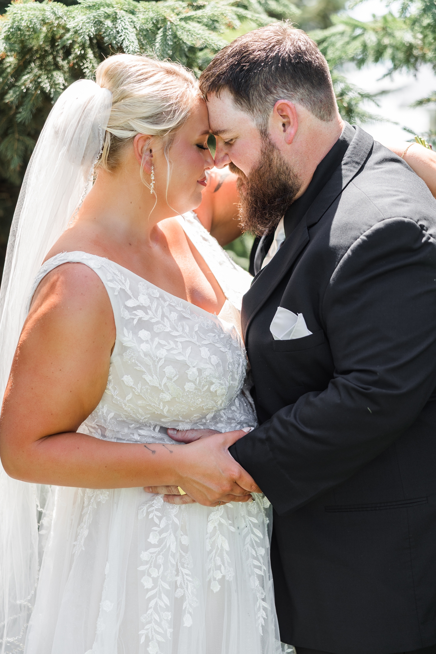 Teri and Dalton lean in close resting their foreheads together on their wedding day amongst the pines on their property | CB Studio