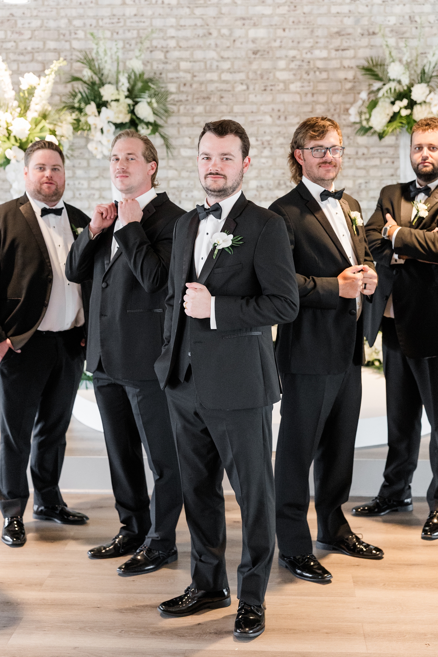 Grant standing stoically with his groomsman at Toast in Ankeny, IA | CB Studio