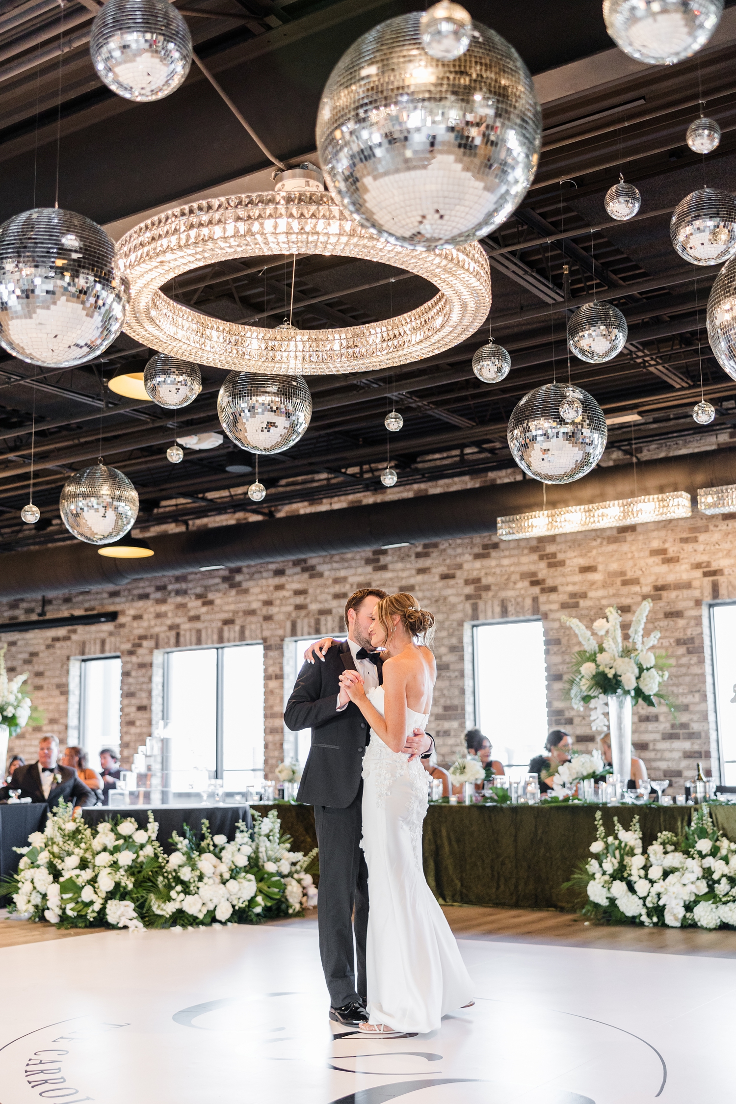 Cassidy and Grant share their first dance as husband and wife under a disco ball filled roof in the ballroom at Toast in Ankeny, IA | CB Studio