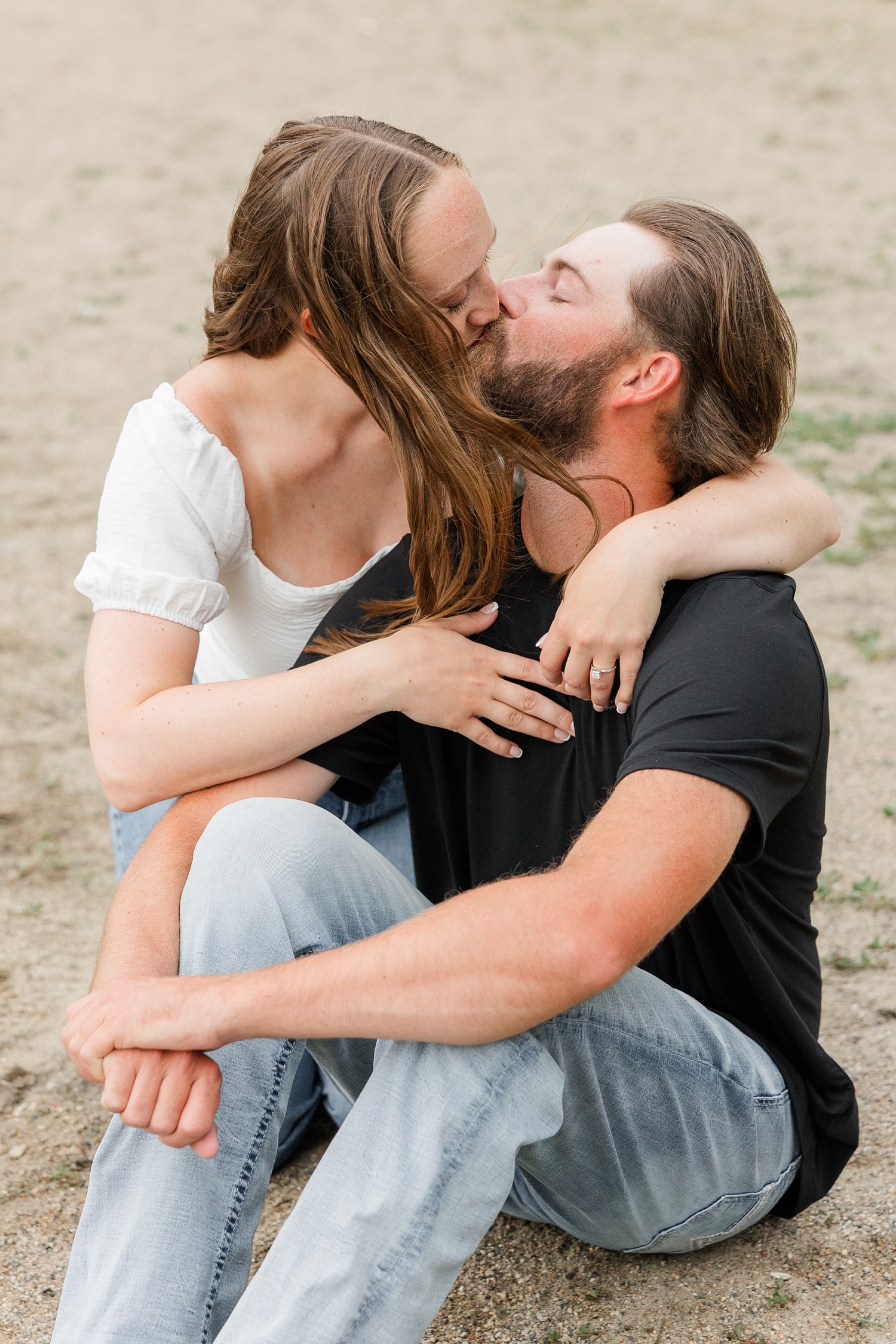 Zach sits on the beach of Lake Cornelia while Chloe embraces him from behind and they share a kiss | CB Studio