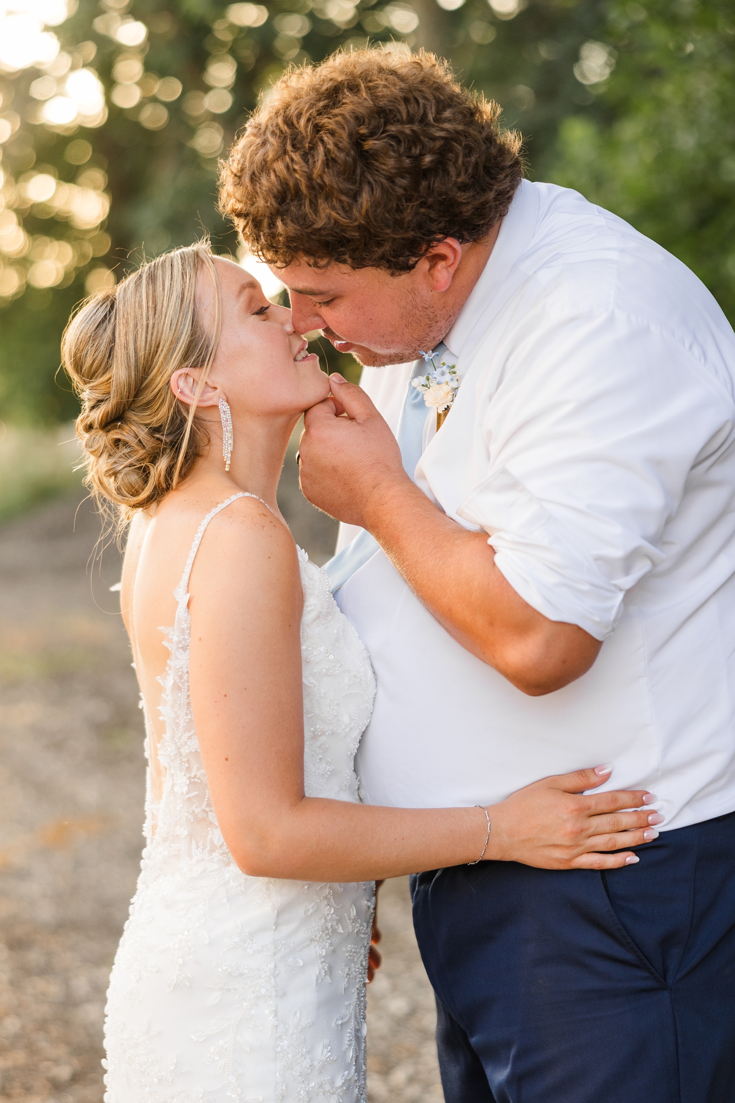 Brandon gently holds Alyssa's chin and pulls her in slowly during golden hour with oak trees in the background | CB Studio