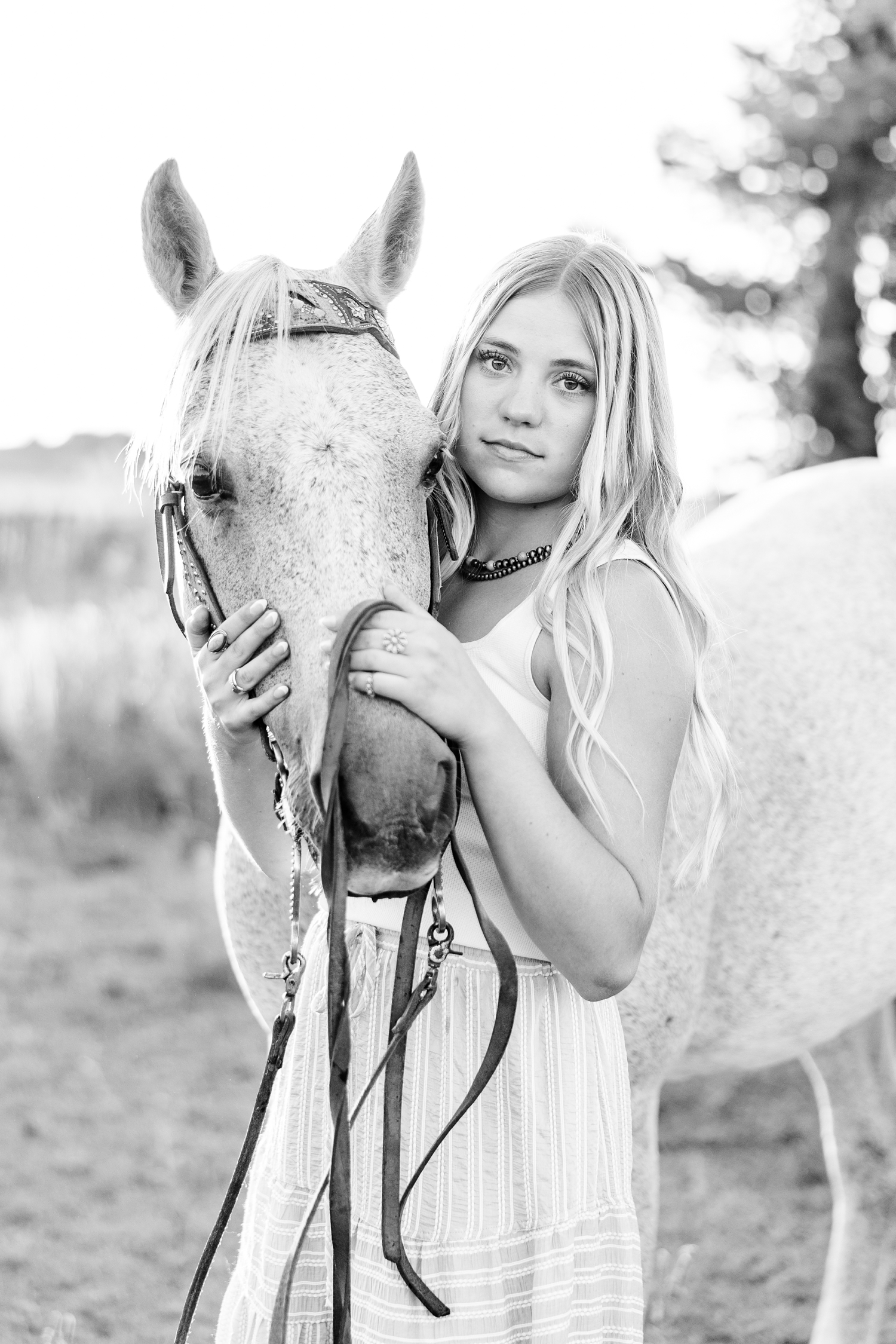 Emma blank stares as she holds the nose of her horse, Dusty, close to her | CB Studio
