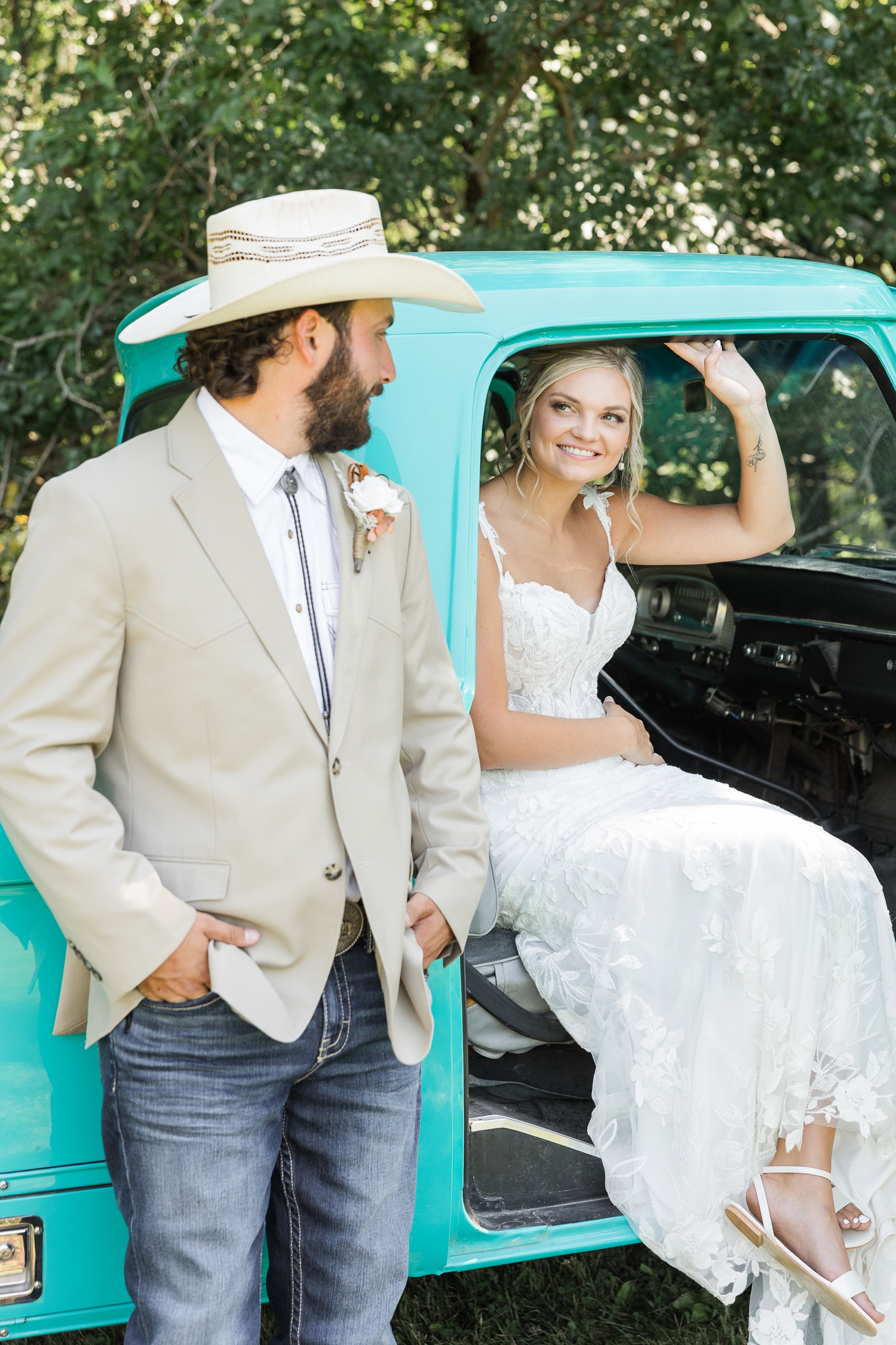 Jade sits in the passenger seat of an old restore turquoise Ford truck as she smiles at Dawson who is leaning his back against the truck next to Jade | CB Studio