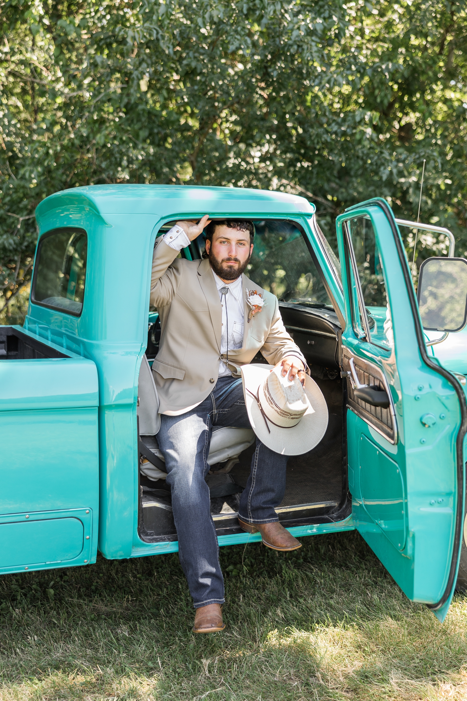 Dawson sits in the passenger seat of an old restore turquoise Ford truck as he is about to step out of it | CB Studio