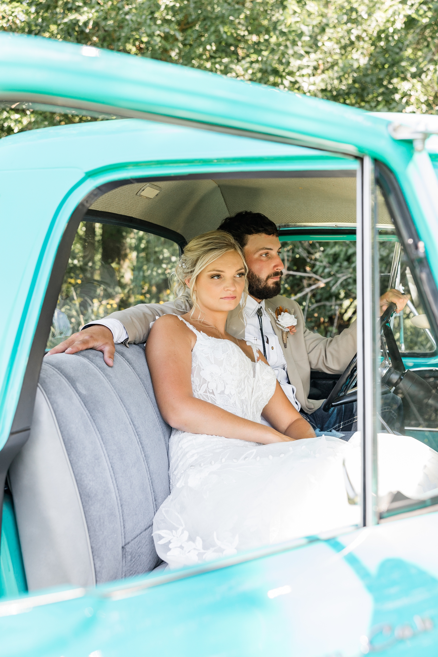 Jade and Dawson sit in the cab of an old restore turquoise Ford truck as Dawson is in the driver's seat and Jade snuggles in next to him | CB Studio