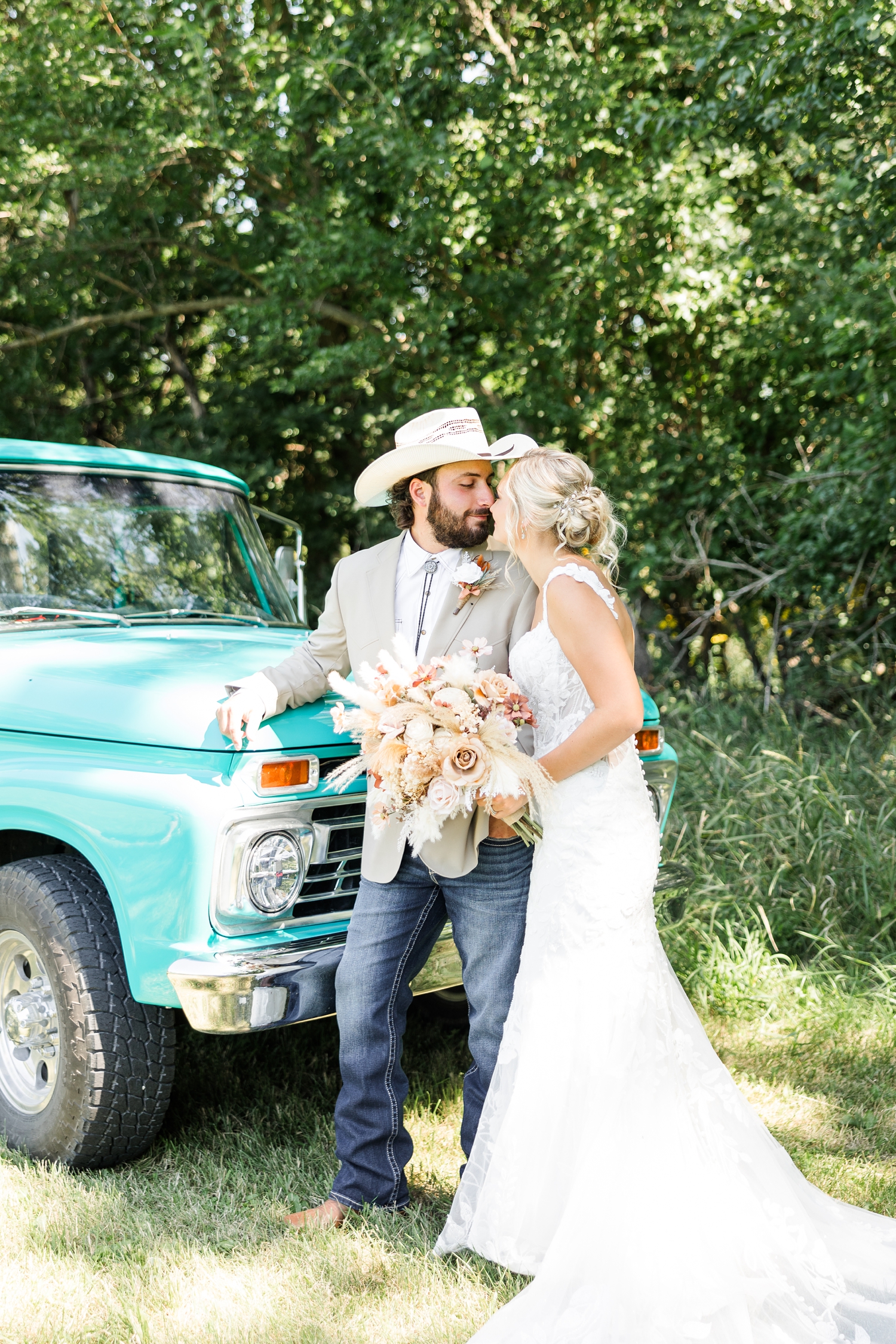 Dawson leans on the hood of an old restore turquoise Ford truck as him and Jade touch noses | CB Studio