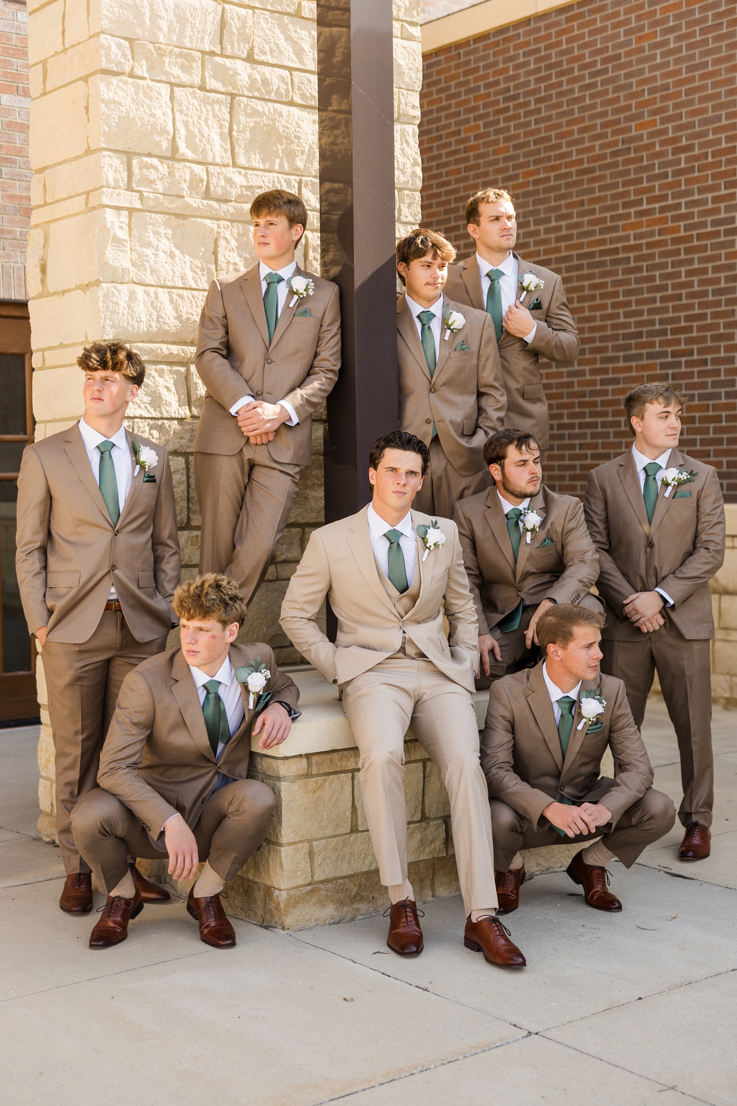 Groom and groomsmen pose stoically in front of the Holy Trinity Catholic Church in Fort Dodge, IA | CB Studio