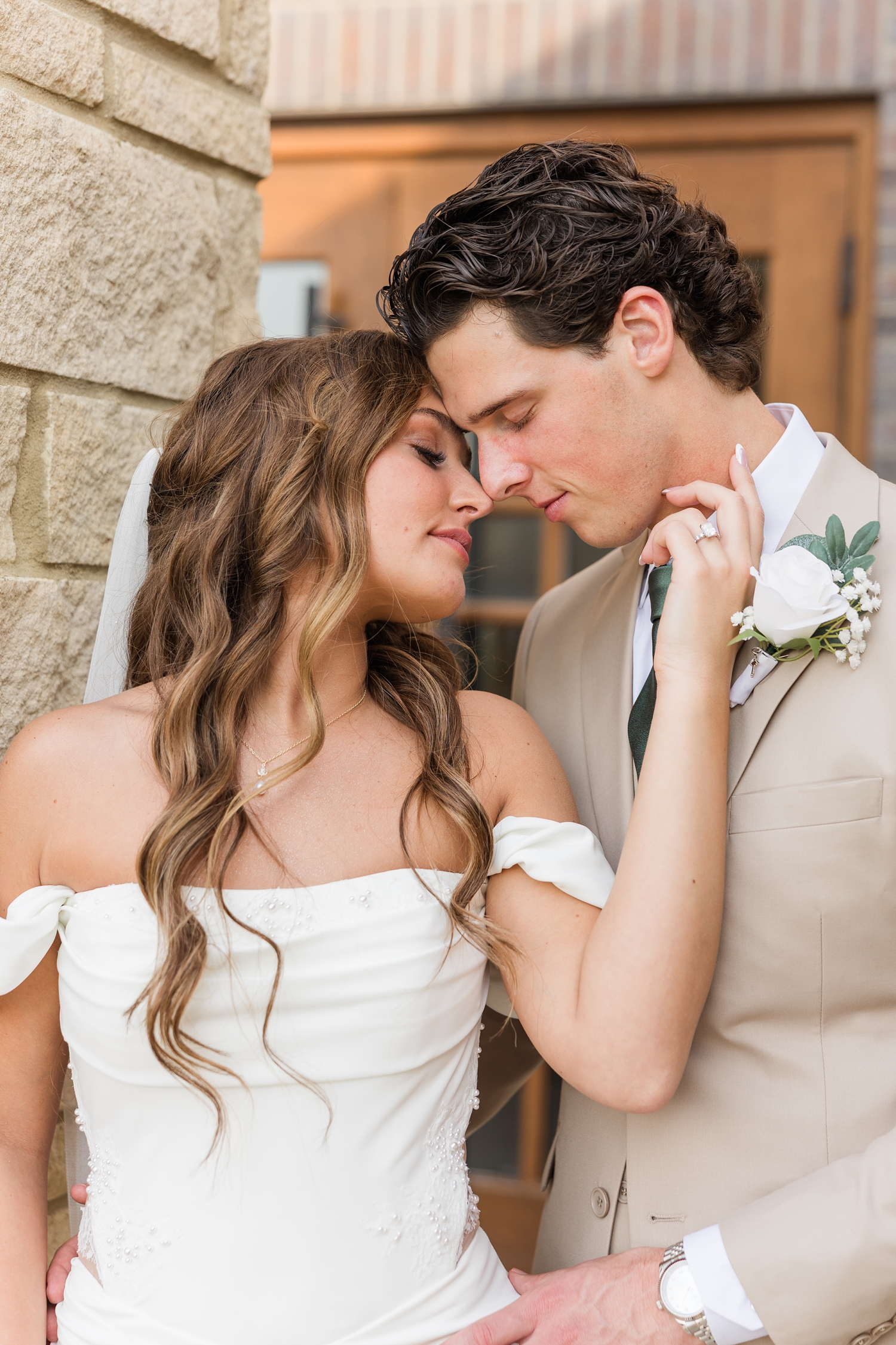 Bride and groom embrace closely as they rest their foreheads together | CB Studio
