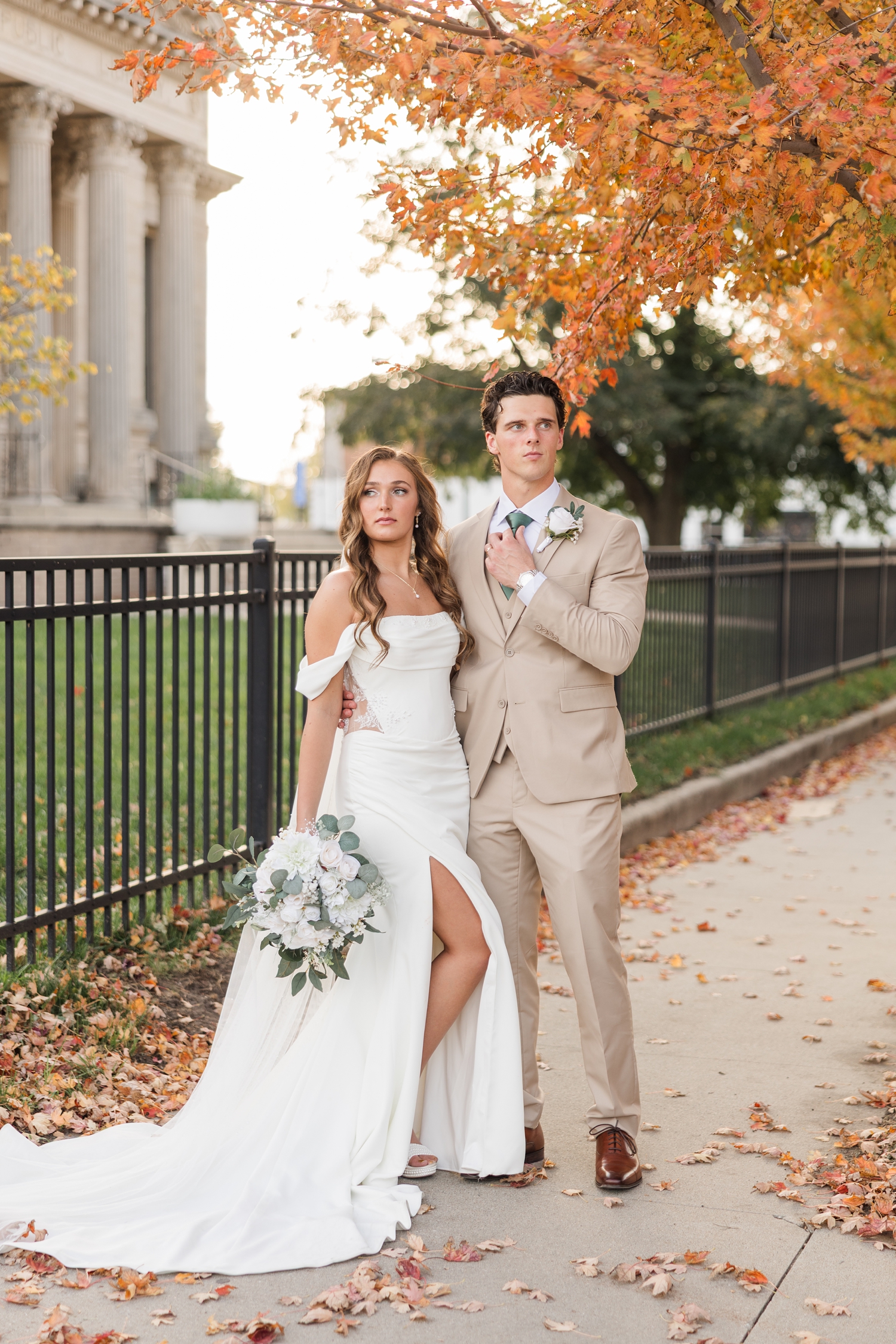 Bride and groom model pose on a sidewalk in downtown Fort Dodge, IA | CB Studio
